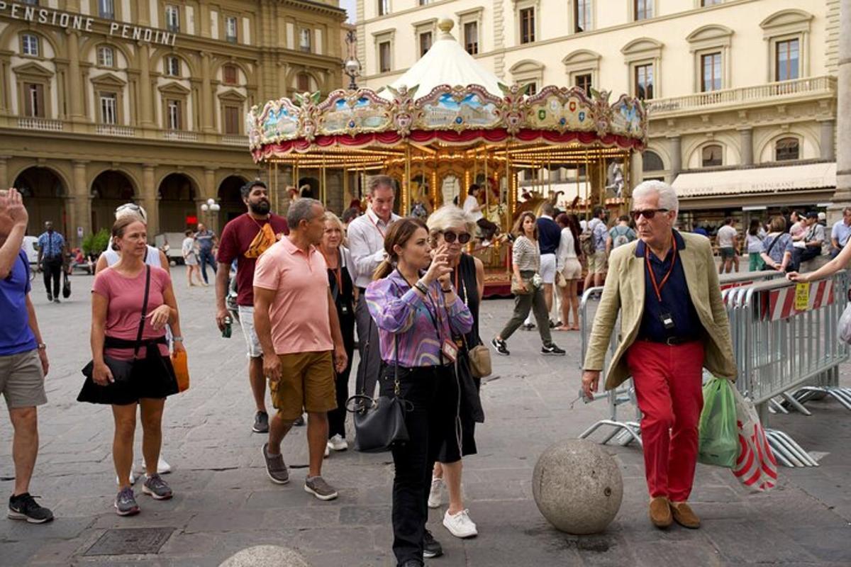 un gruppo di persone che camminano davanti a una giostra