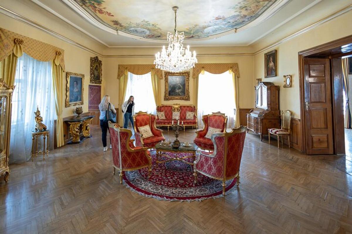 uma sala com um lustre, uma mesa e cadeiras