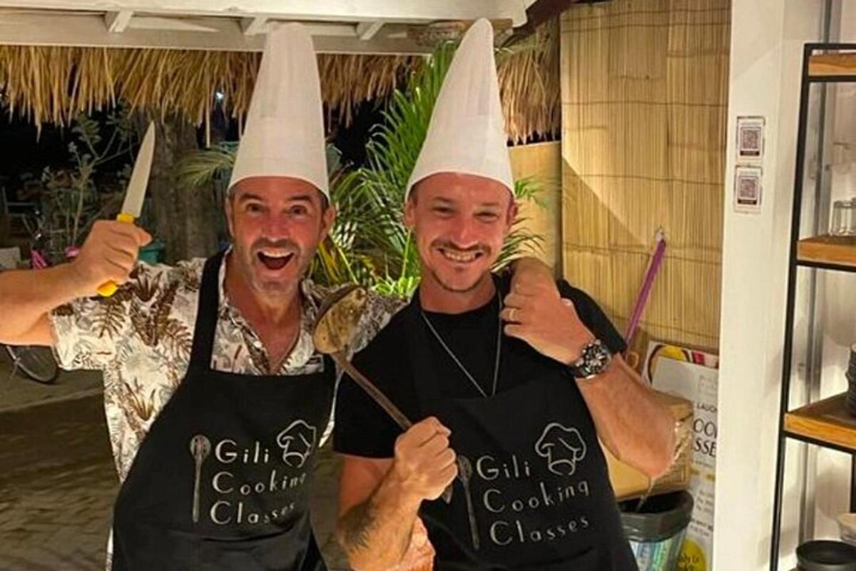 two men wearing chefs hats posing for a picture