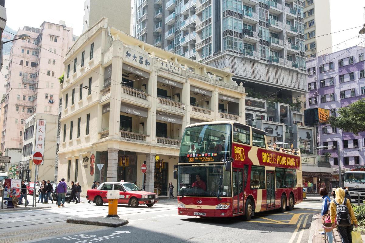 a red double decker bus driving down a city street