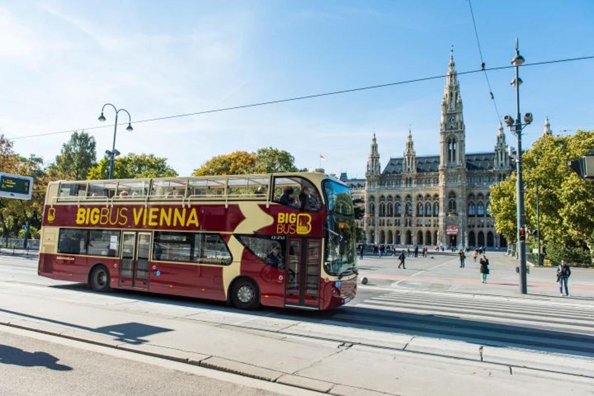 rdeč dvonadstropni avtobus, ki se vozi po mestni ulici