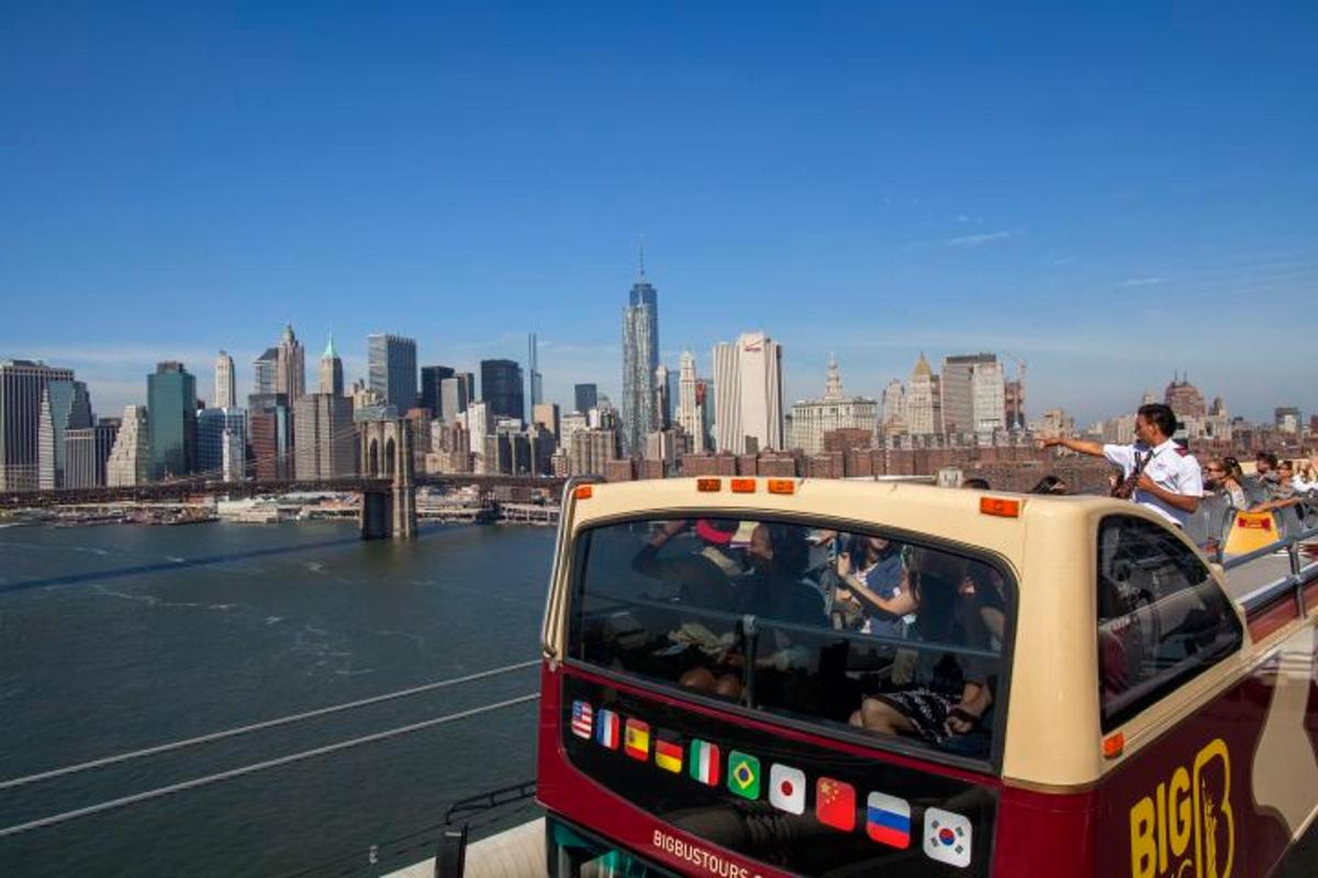 a bus driving down a river next to a city