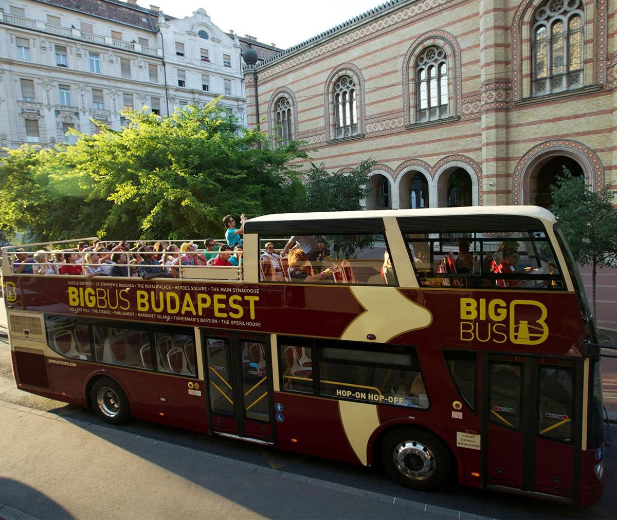 a red double decker bus driving down a street