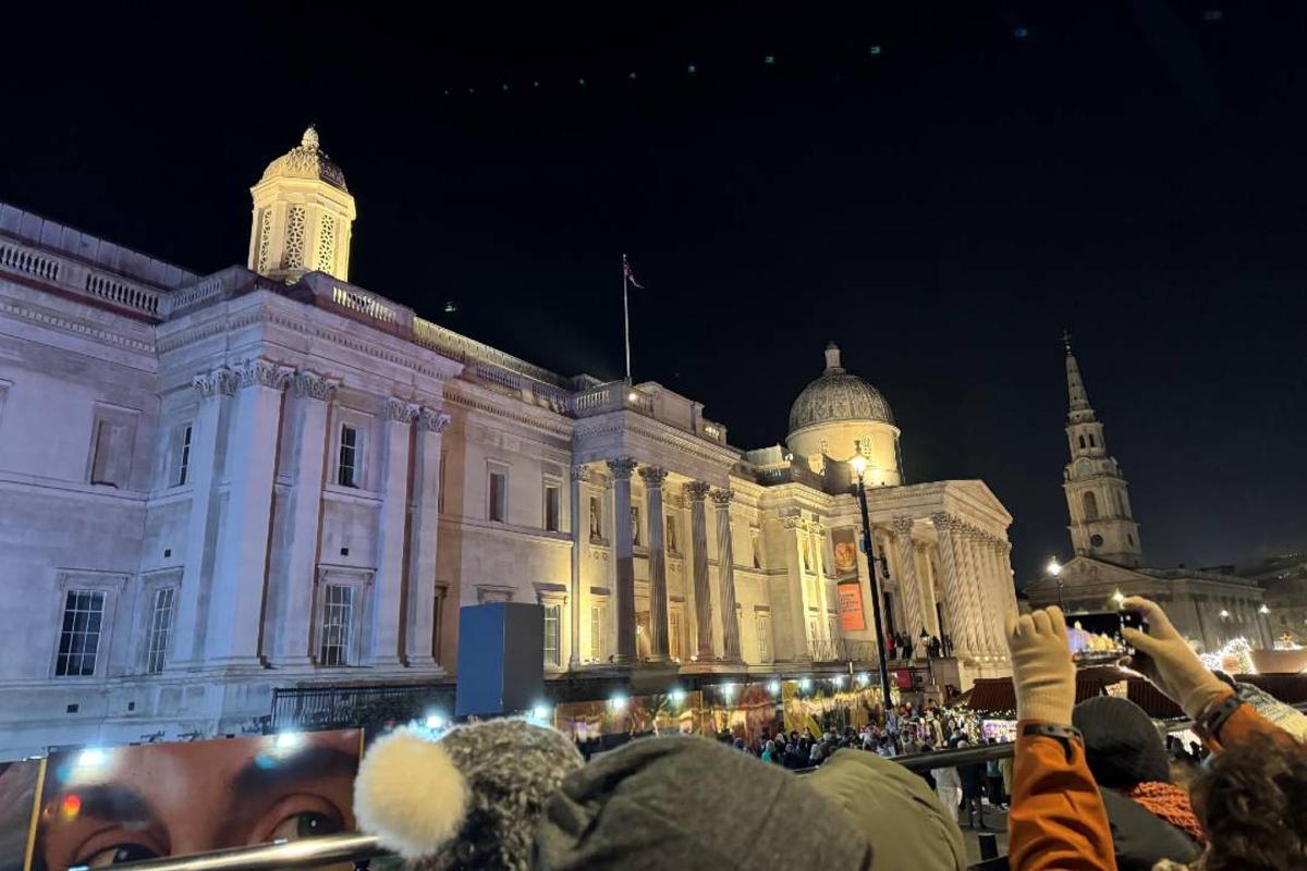 a crowd of people taking pictures of a building at night