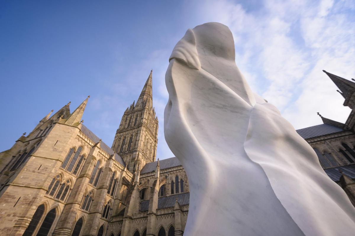 uma estátua em frente a um prédio com uma igreja