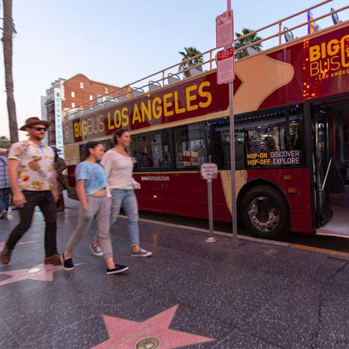 a group of people walking in front of a bus