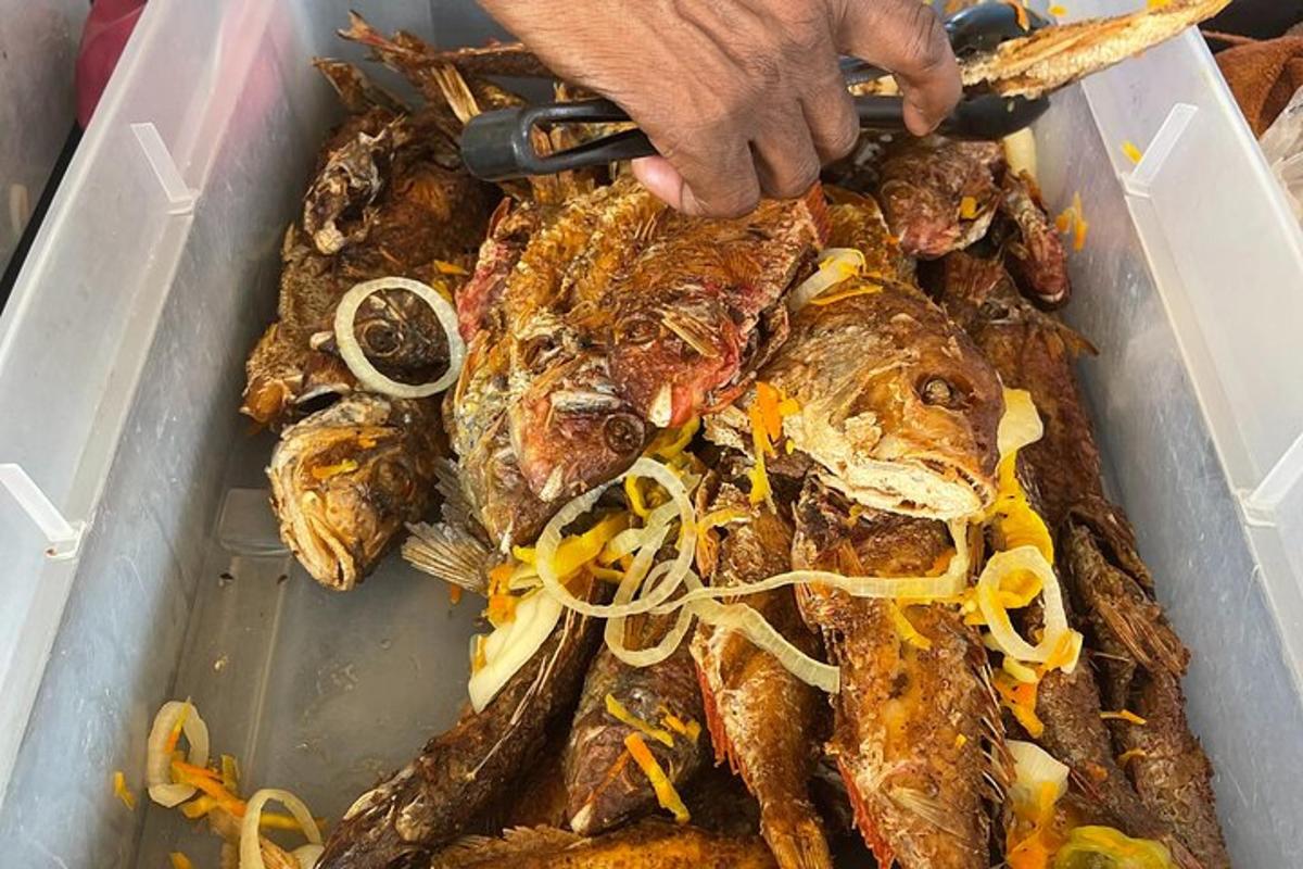 死んだ魚の入ったトレイとナイフを持った人