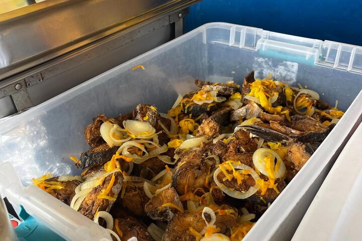 Un recipiente de plástico lleno de comida con champiñones y cebollas.