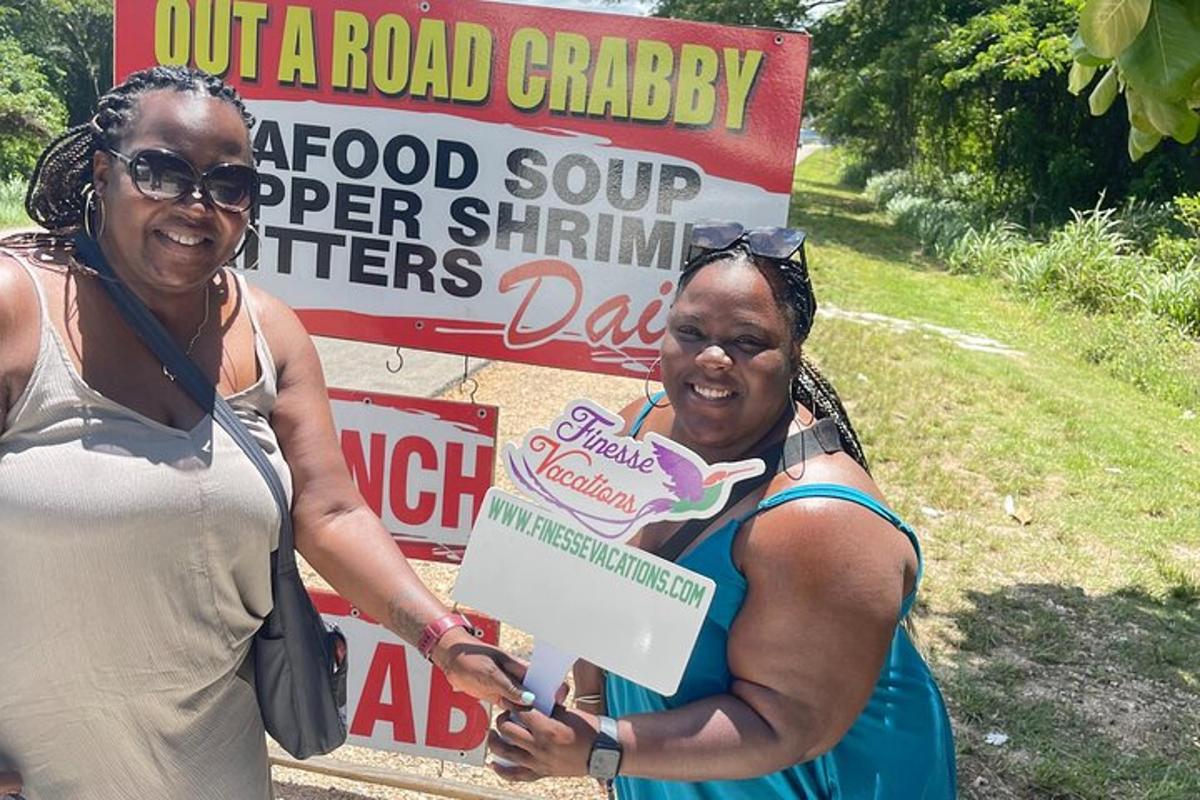 Dos mujeres paradas frente a un cartel de caridad en la carretera