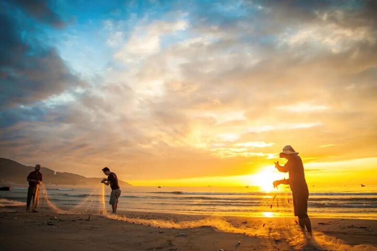 a group of people on the beach at sunset