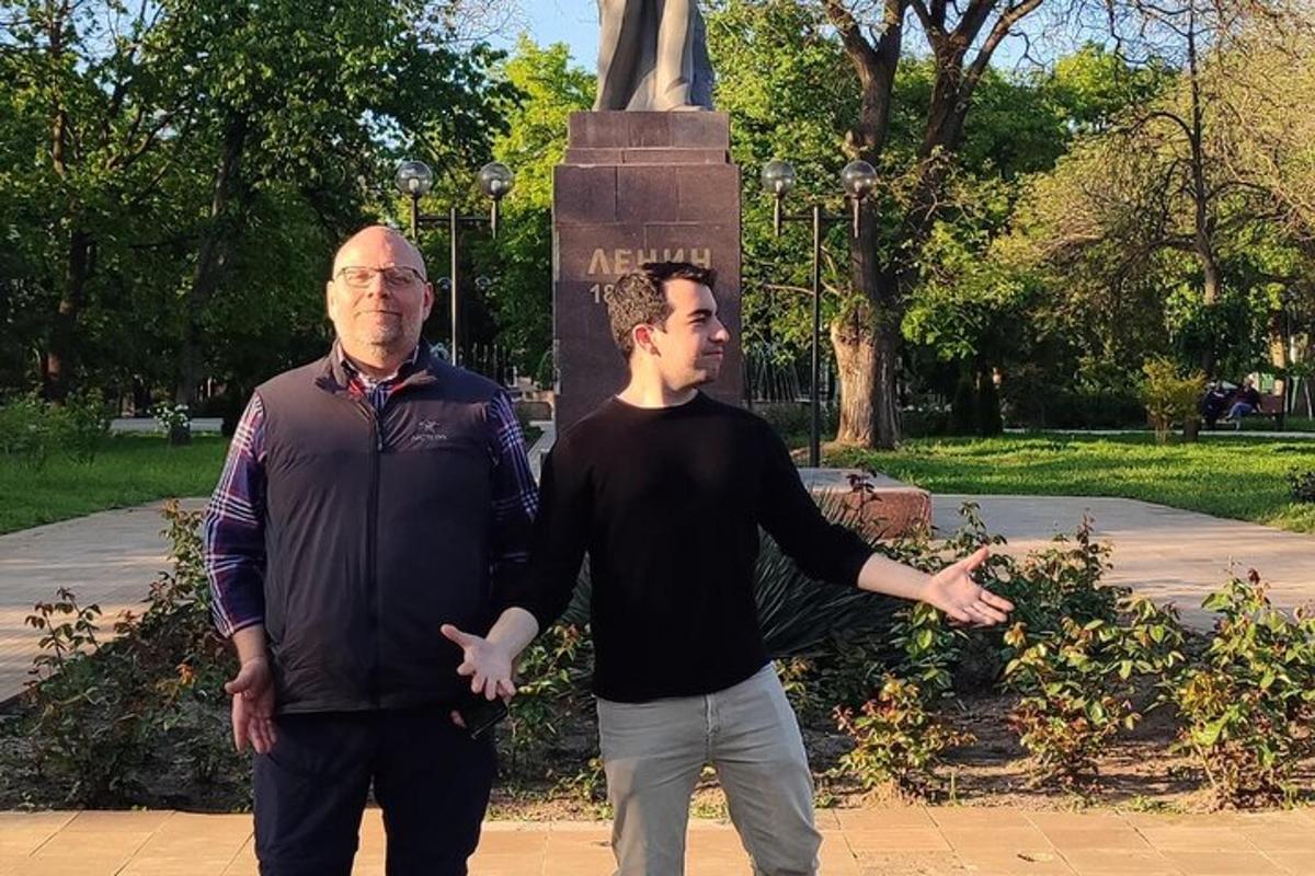 two men are standing in front of a statue