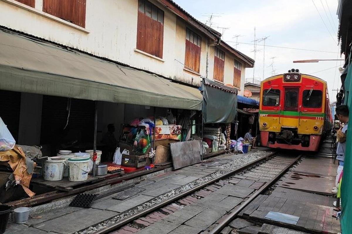 kereta api yang bergerak melepasi bangunan bersebelahan stesen kereta api