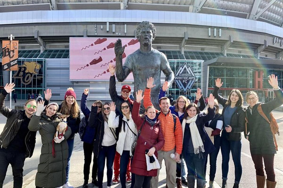 Un grupo de personas de pie frente a una estatua
