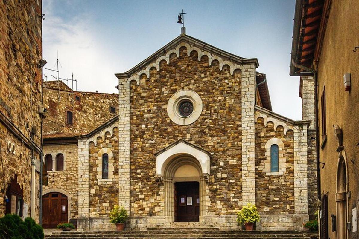 Una antigua iglesia de piedra con una cruz en la parte superior.