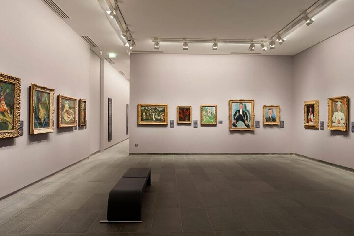resimlerin bulunduğu bir odada bir bankın bulunduğu bir sanat galerisi