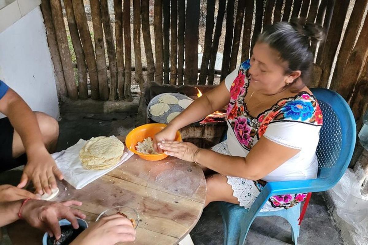 moteris, sėdinti prie stalo su lėkšte maisto