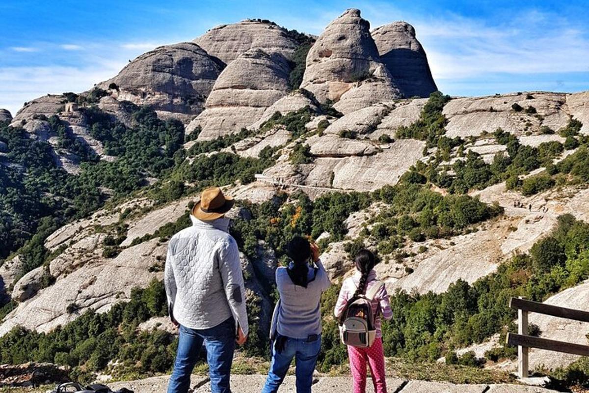 a group of three people looking at a mountain