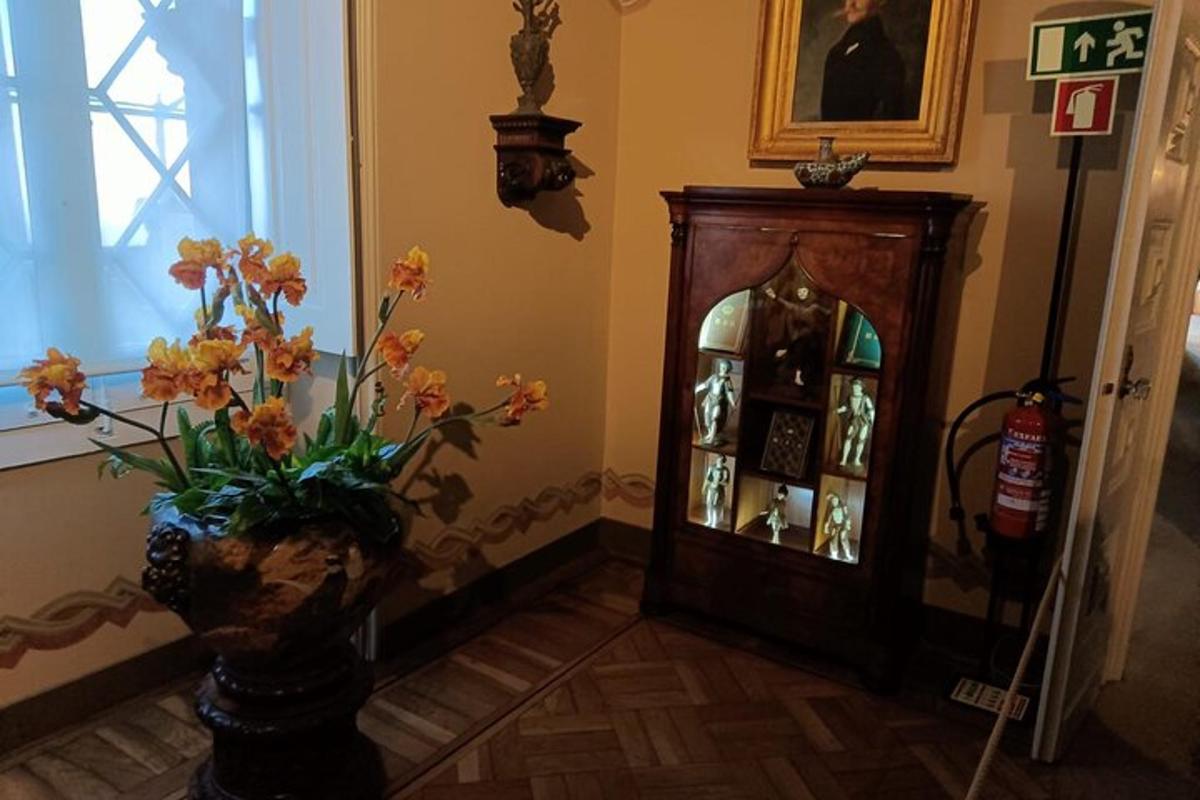 a vase with flowers in a room with a clock