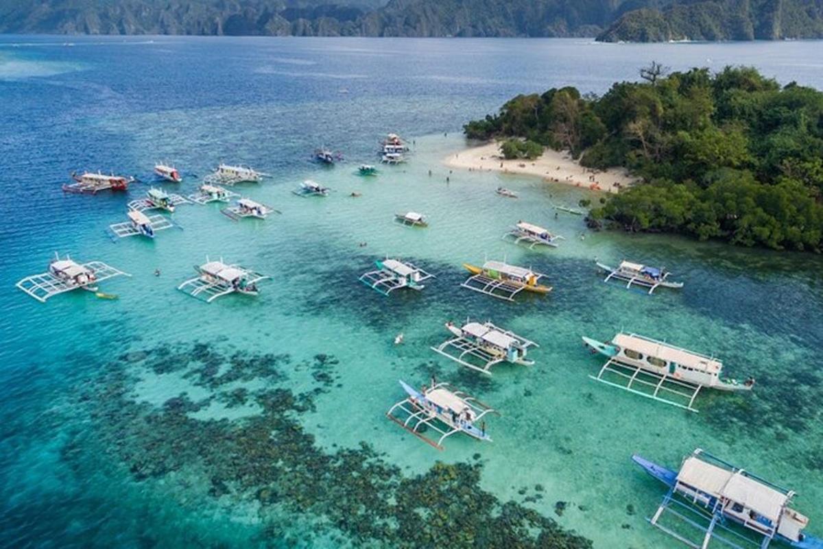 an aerial view of a beach with boats in the water
