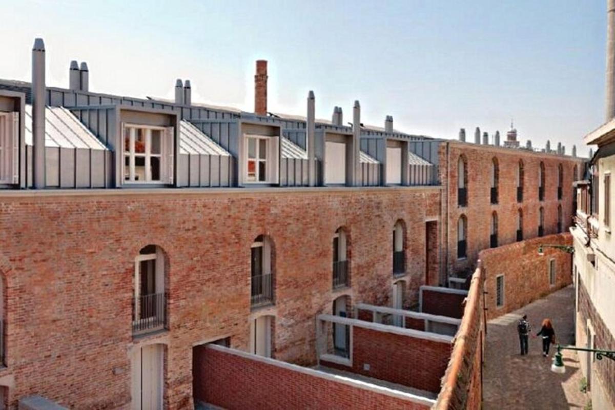 un vecchio edificio in mattoni con persone che camminano sul tetto