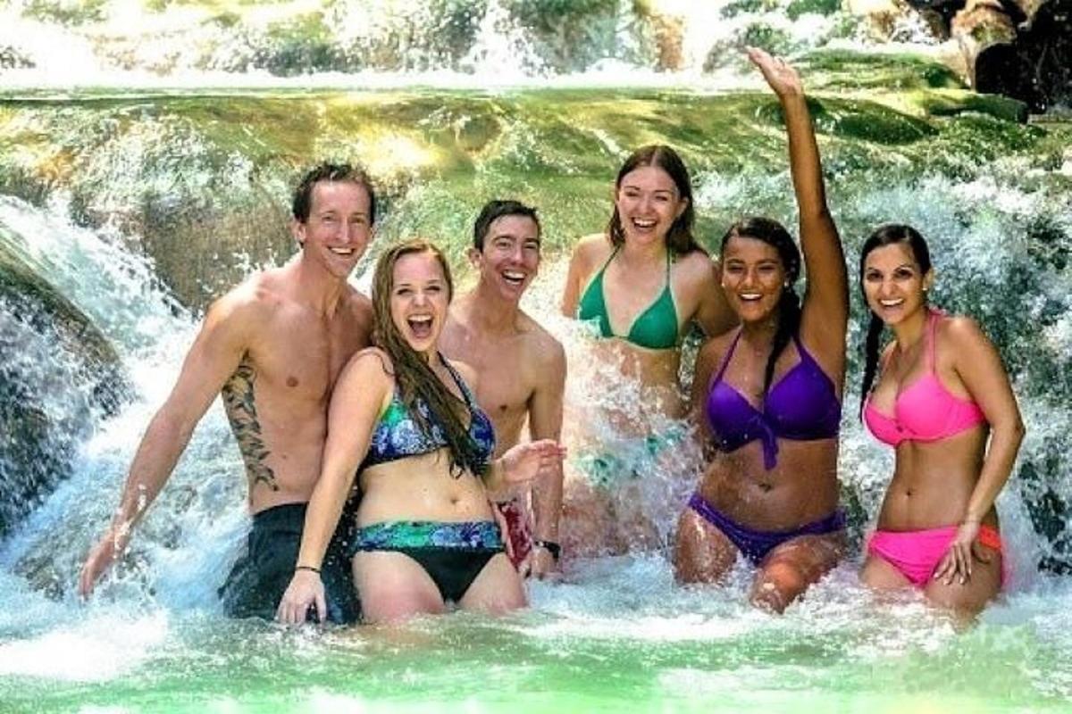 un grup de oameni în costume de baie într-o cascadă