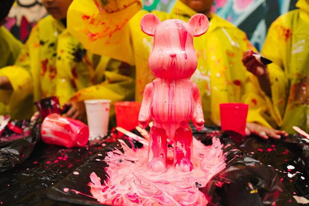 um rato de brinquedo rosa sentado em cima de um bolo