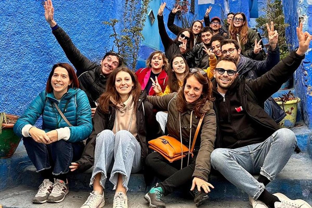 un grup de persones posant davant d'una paret blava