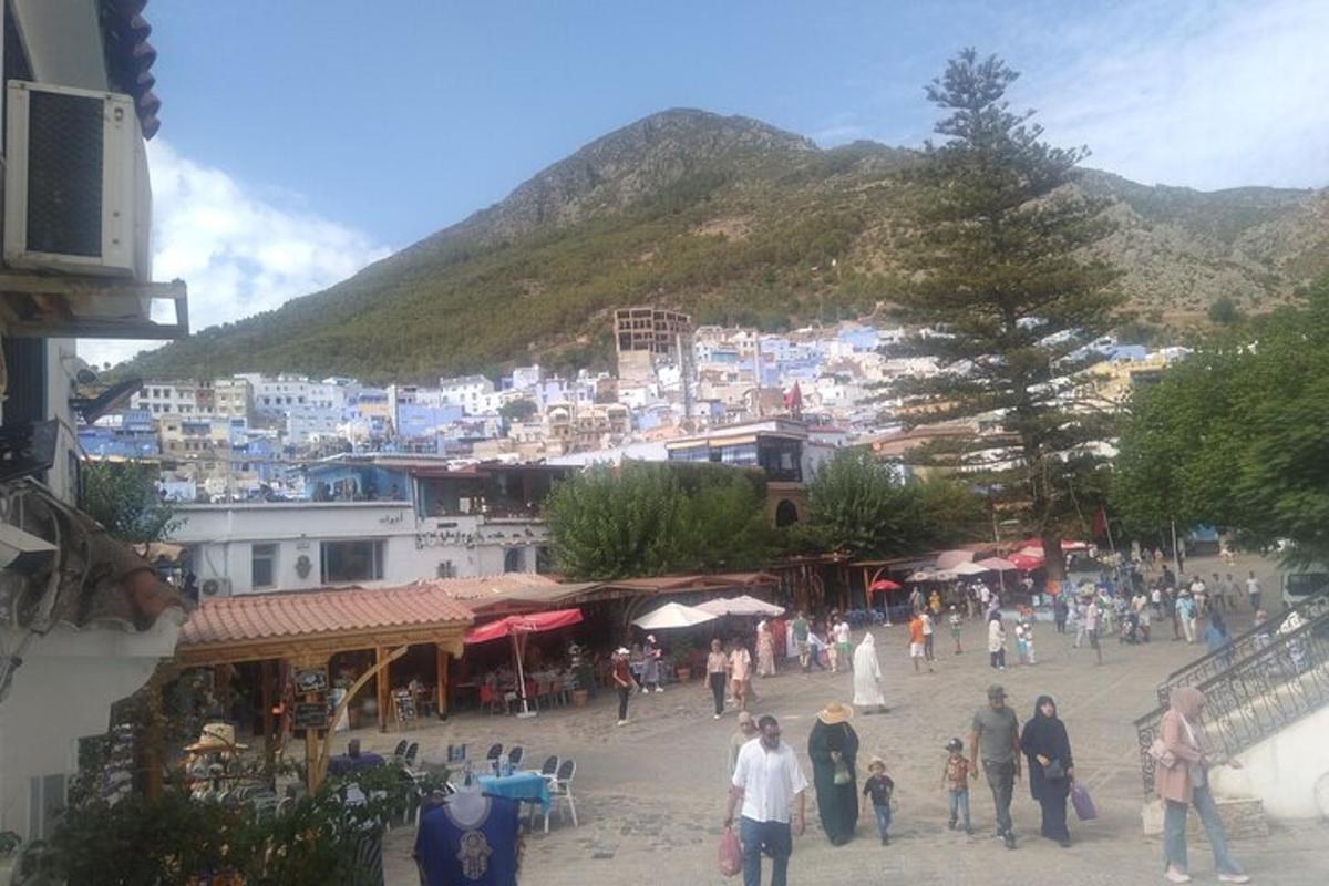 un grup de persones caminant per un poble amb una muntanya