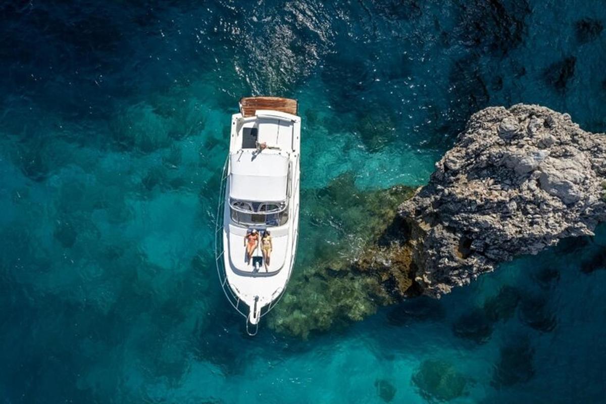 una barca bianca nell'acqua accanto a una roccia