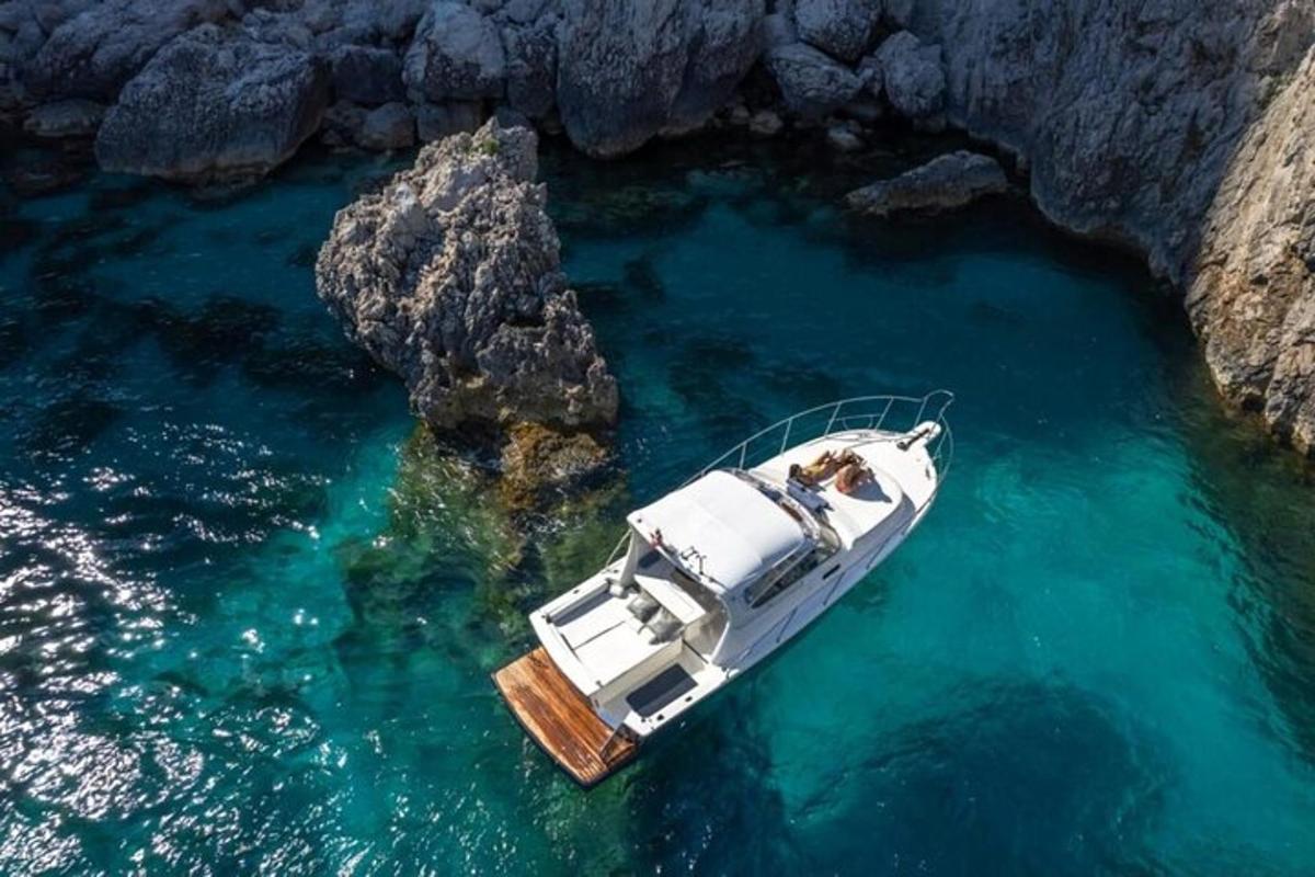 una barca in acqua accanto a una scogliera