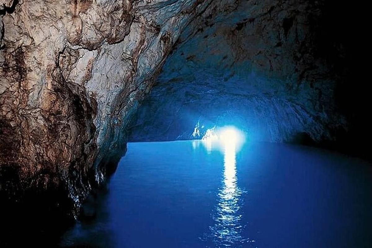 uma caverna escura com uma luz na água