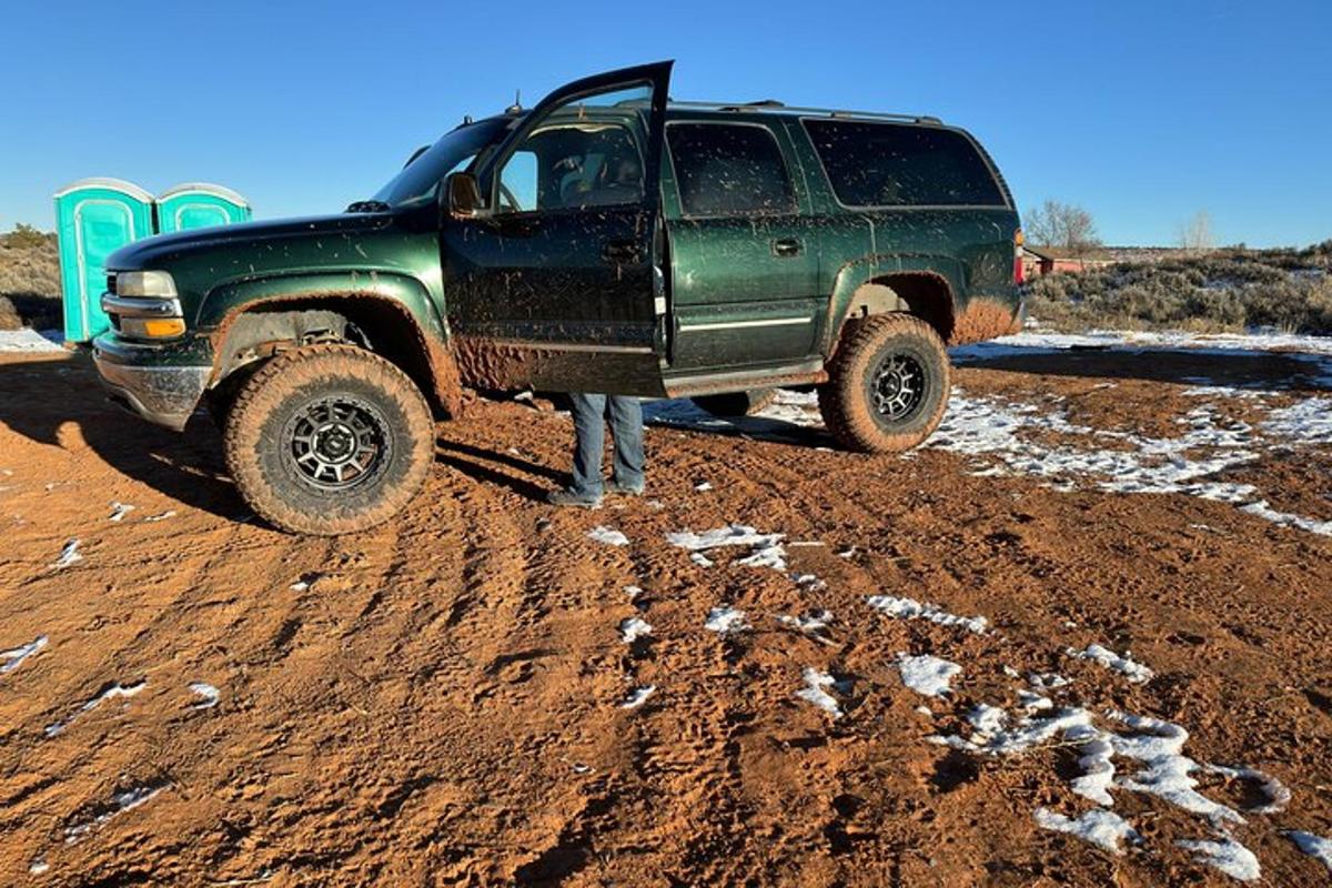 a green truck parked on a dirt road