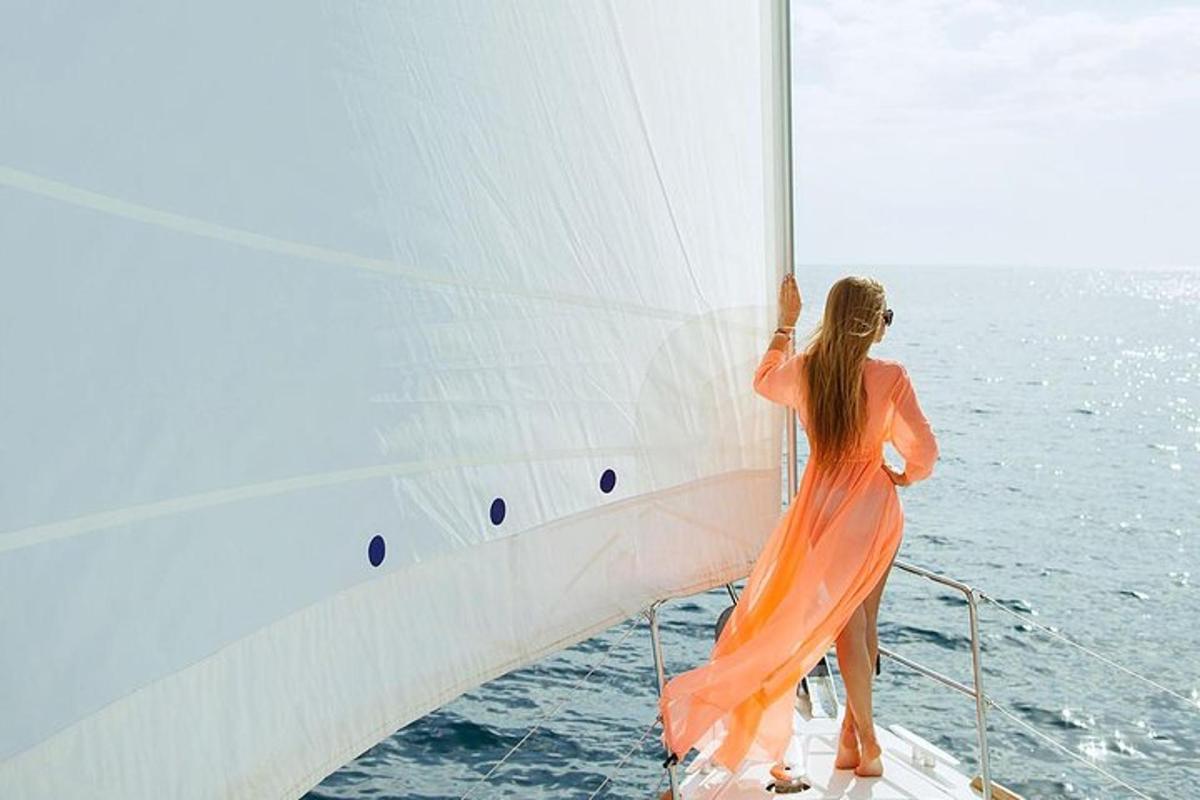 a woman in an orange dress standing on a boat