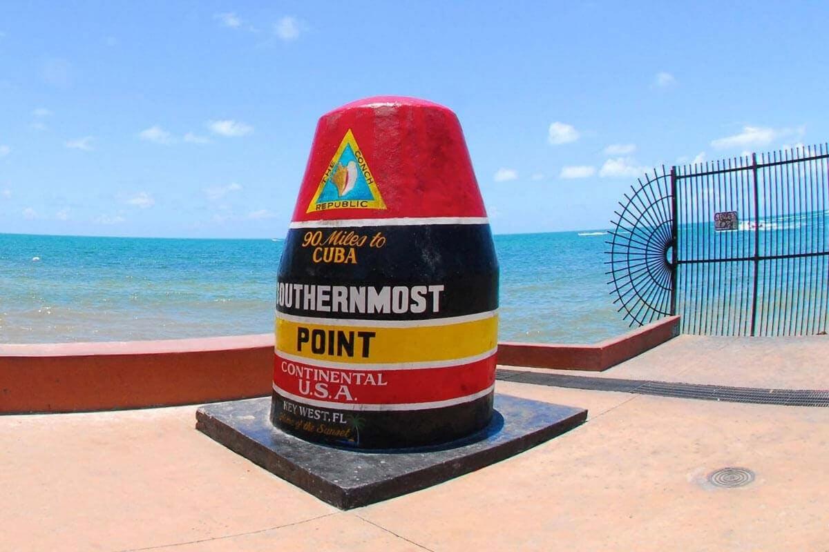 a sign on the beach with the ocean in the background