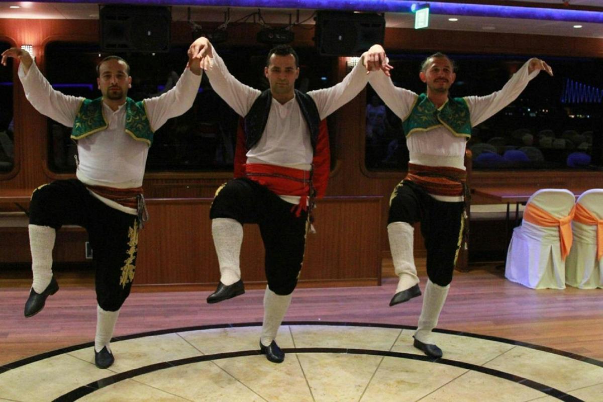 un grup de tres homes ballant en una pista de ball