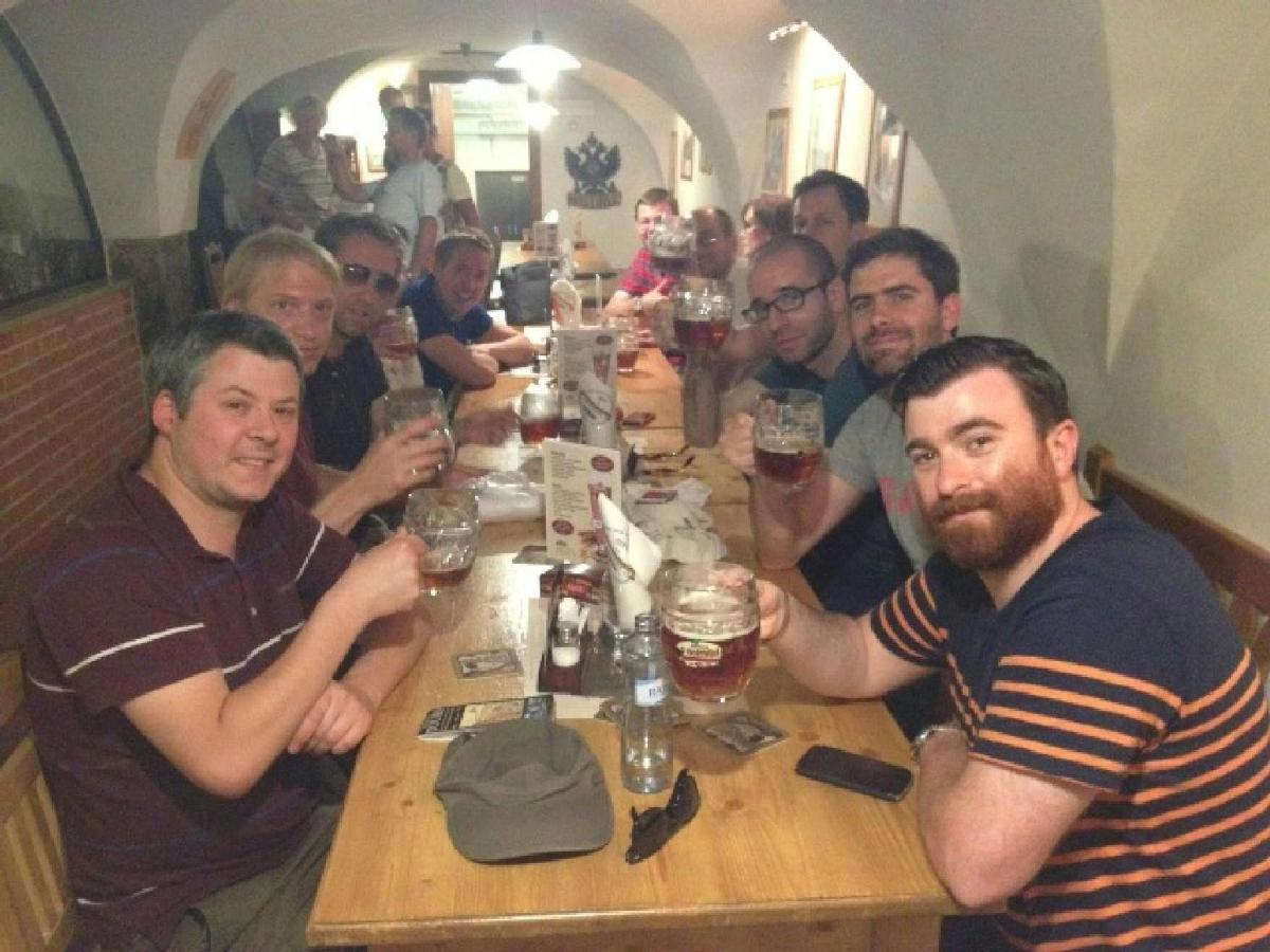 um grupo de homens sentados à mesa bebendo cerveja