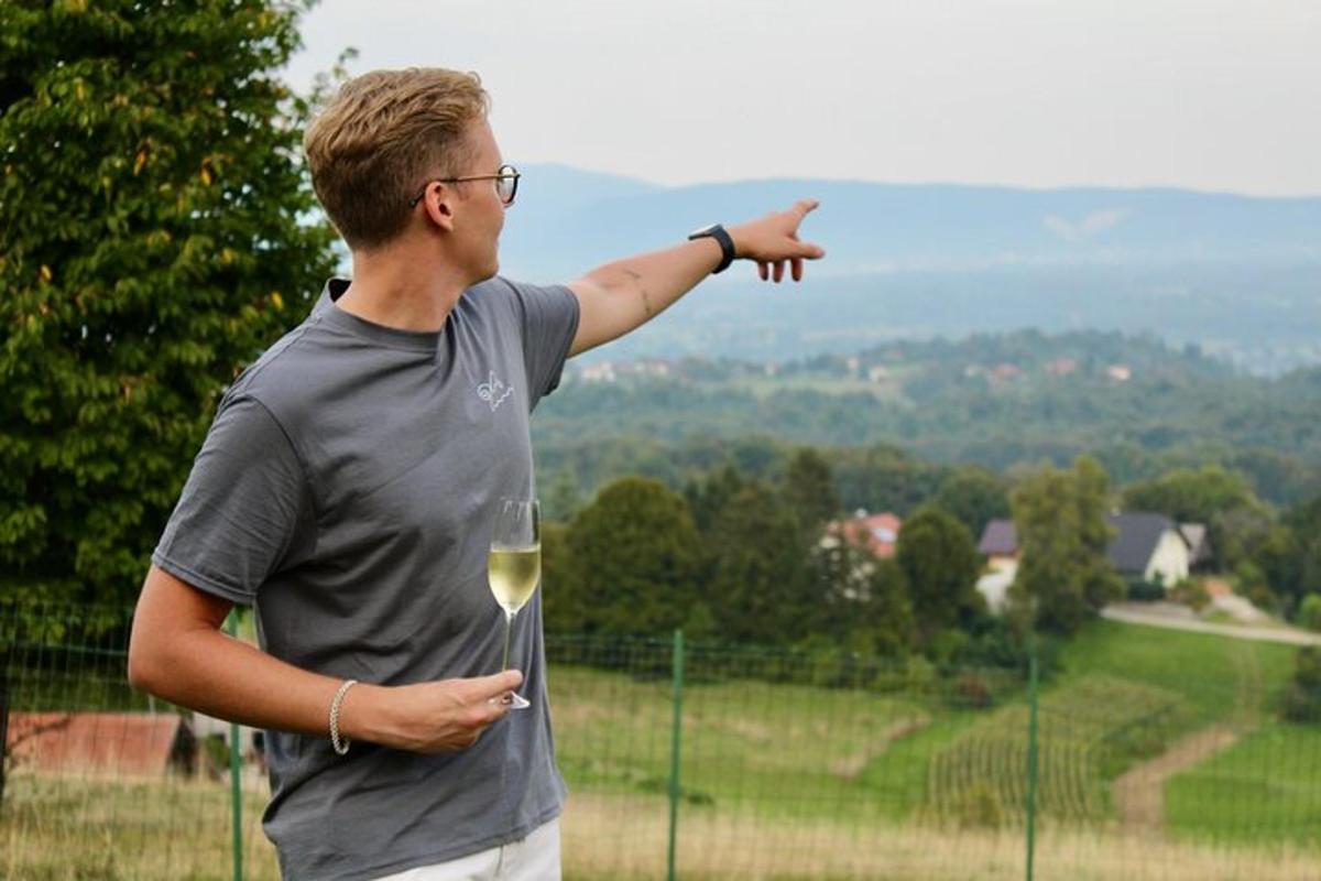 Ein Mann hält ein Glas Wein und zeigt auf etwas