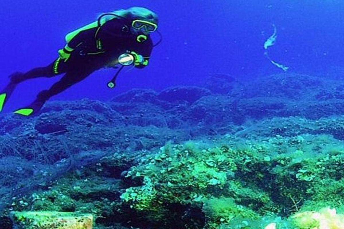člověk se potápí v oceánu poblíž útesů