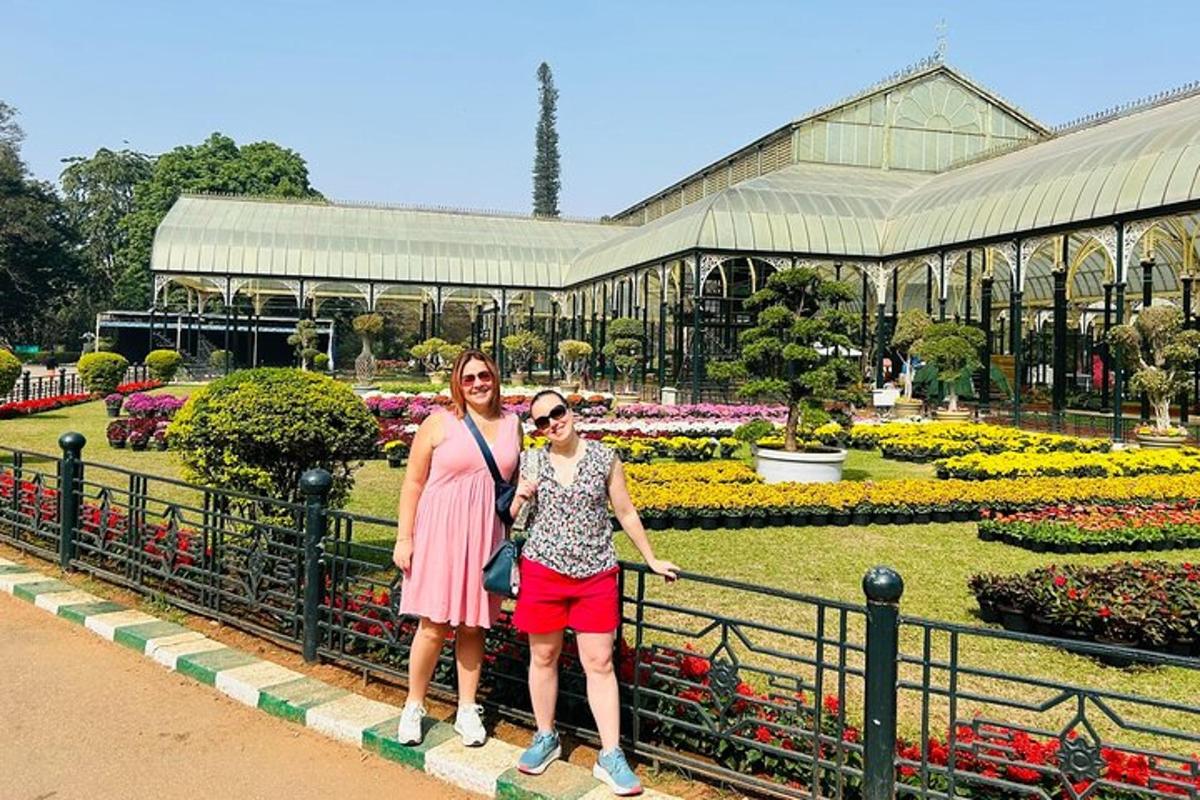 two women are standing in front of a garden