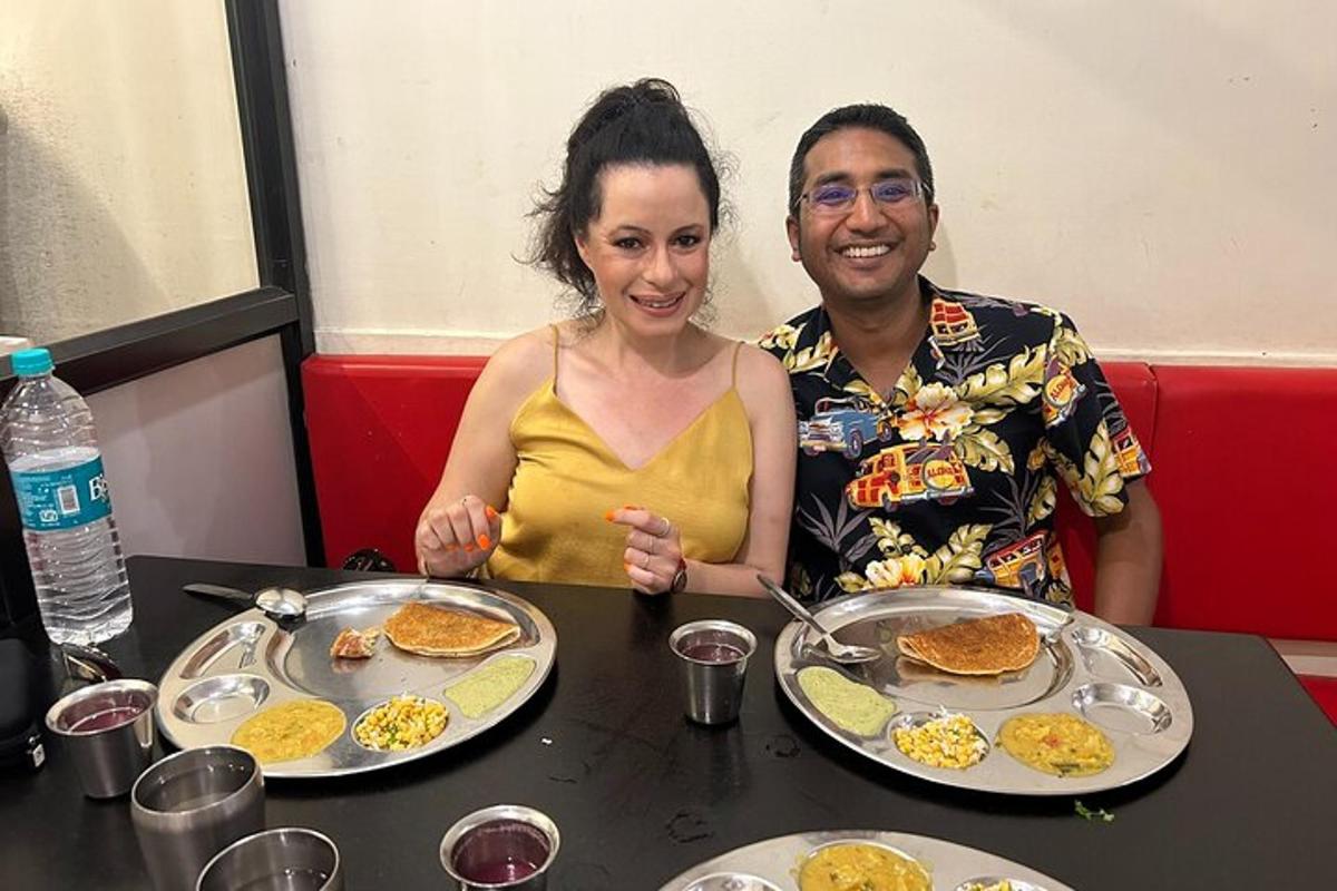 a man and a woman sitting at a table with food