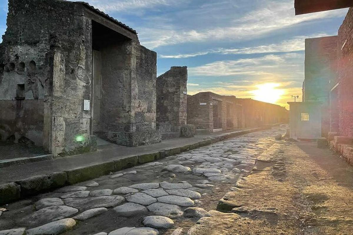 o stradă veche de piatră cu apusul de soare în fundal