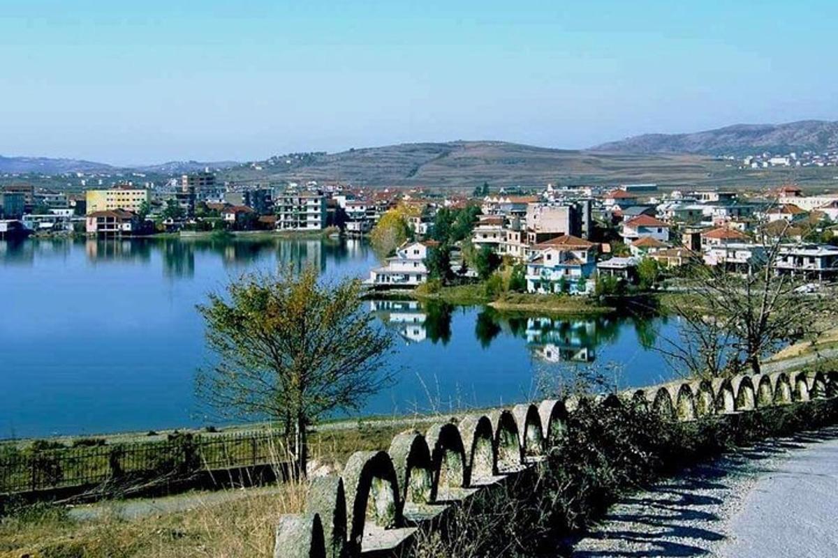 a bridge over a lake with a city in the background