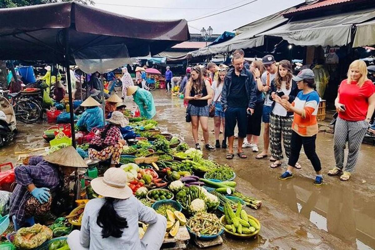 sekumpulan orang berdiri di sekeliling pasar dengan buah-buahan dan sayur-sayuran