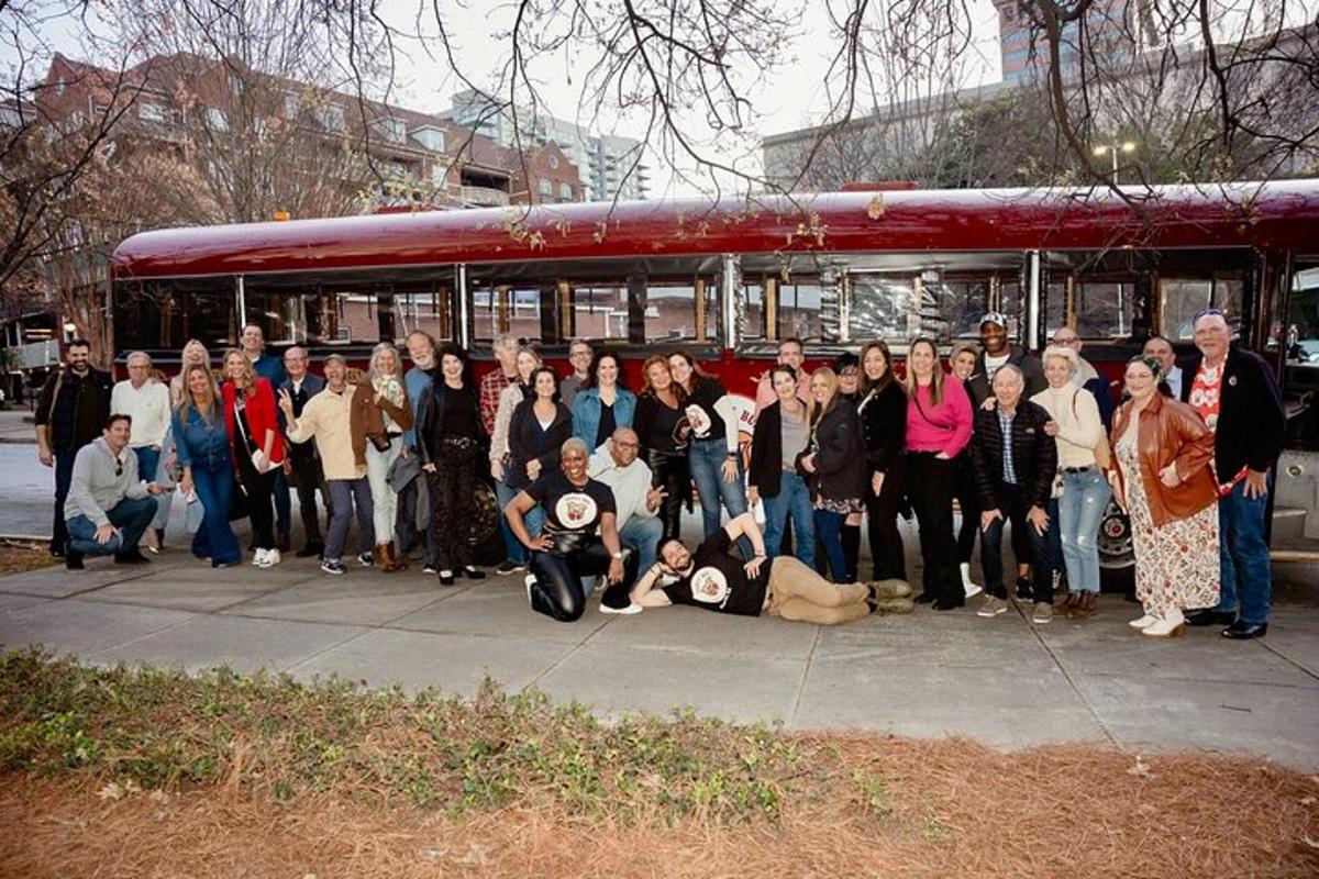 a group of people standing in front of a bus