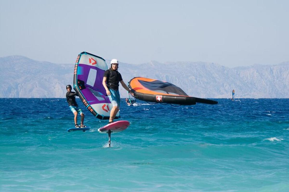 Dos personas de pie sobre una tabla de surf en el agua
