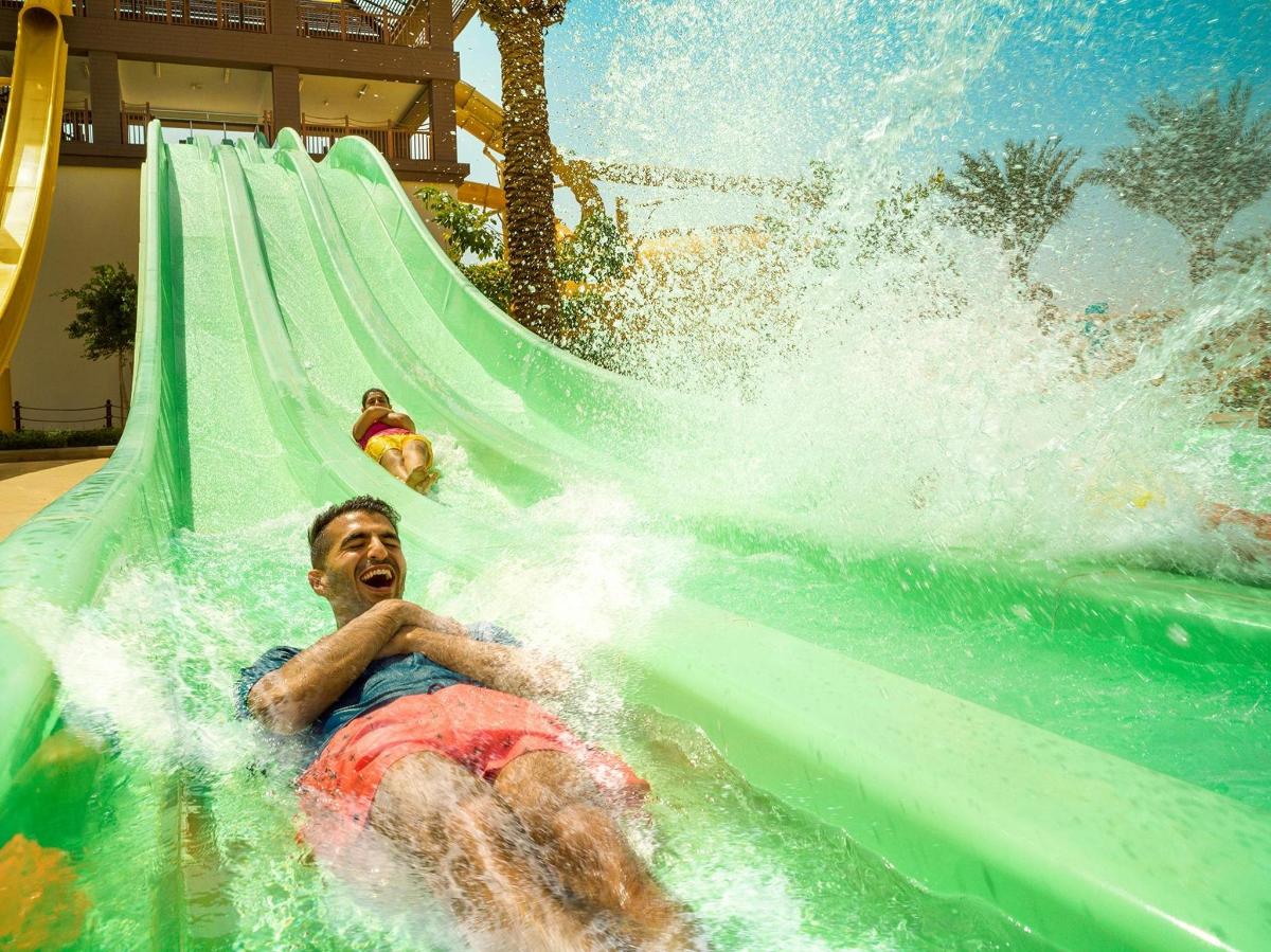 a man riding a water slide at a water park