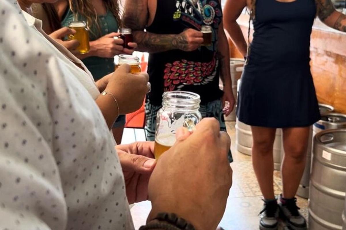 eine Gruppe von Menschen hält Gläser mit Bier hoch