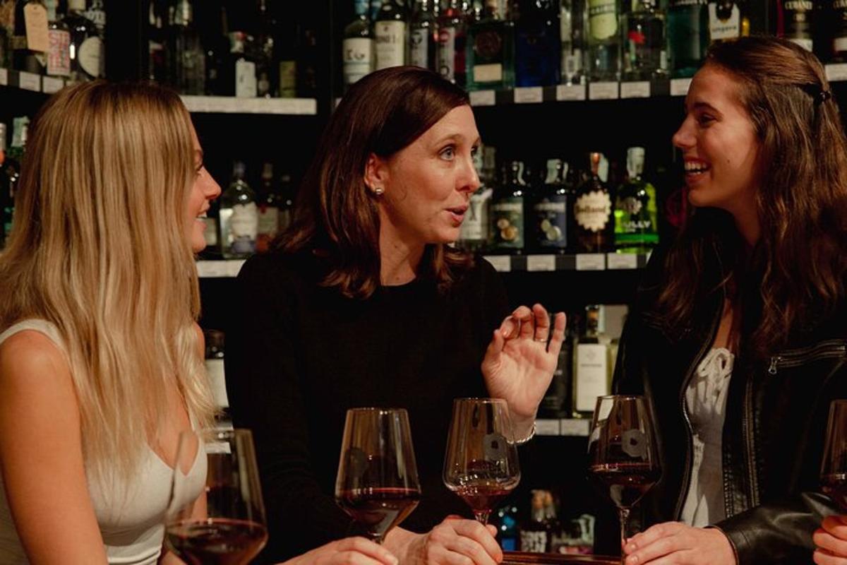 Tres mujeres hablando en un bar con copas de vino