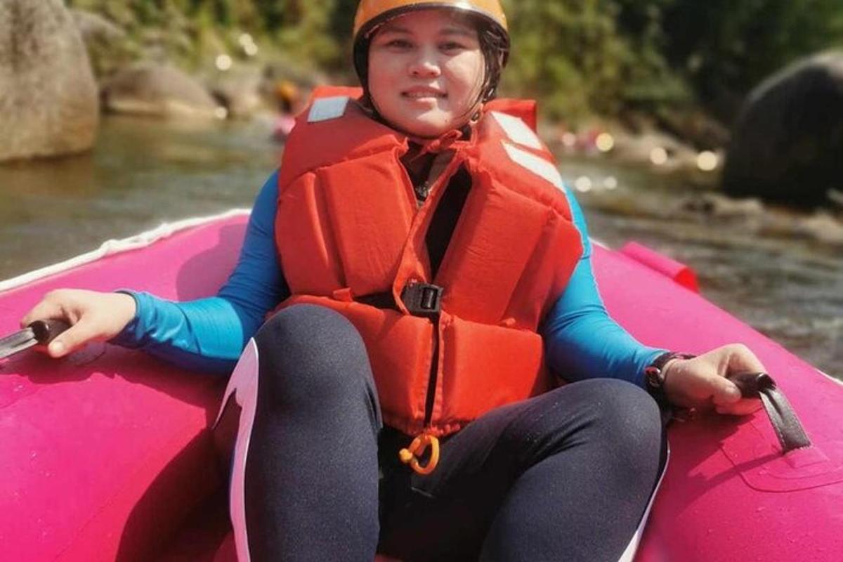 žena sedící v růžovém voru na řece