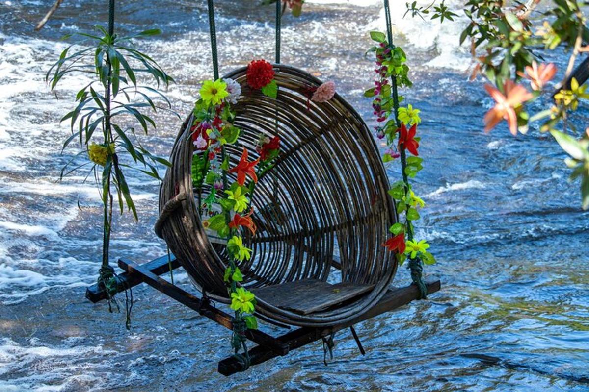 eine Korbschaukel mit Blumen darauf im Wasser